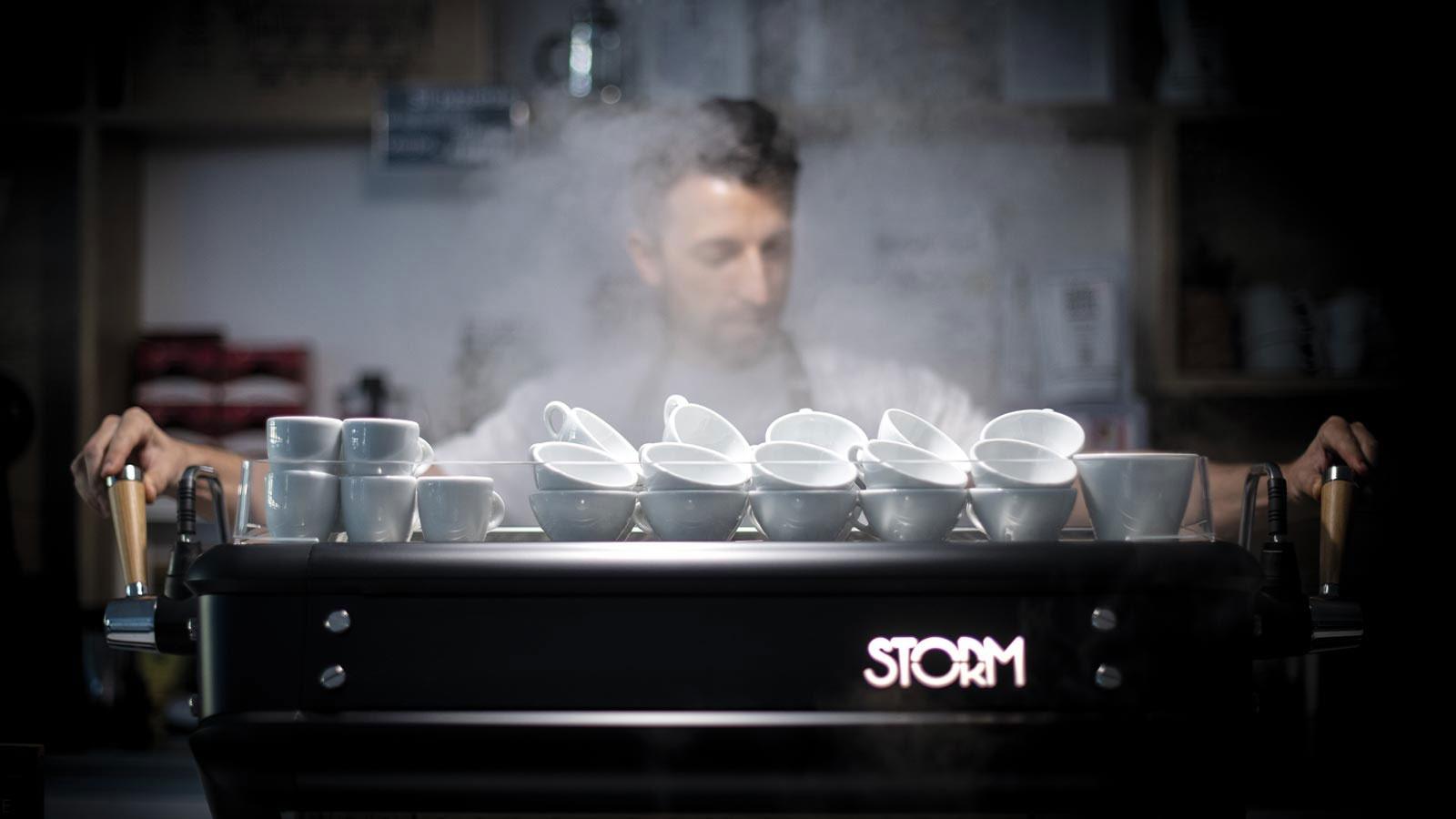 Macchina del caffé fumante con barista che sta preparando un caffé